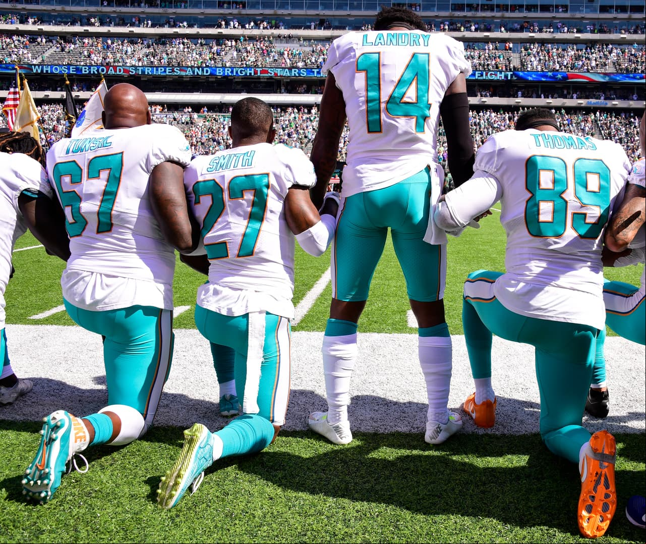 Jarvis Laundry, el único de pie en esta formación de los Miami Dolphins emintras sus compañeros se arrodillaban. Manos entrelazadas en señal de unión.